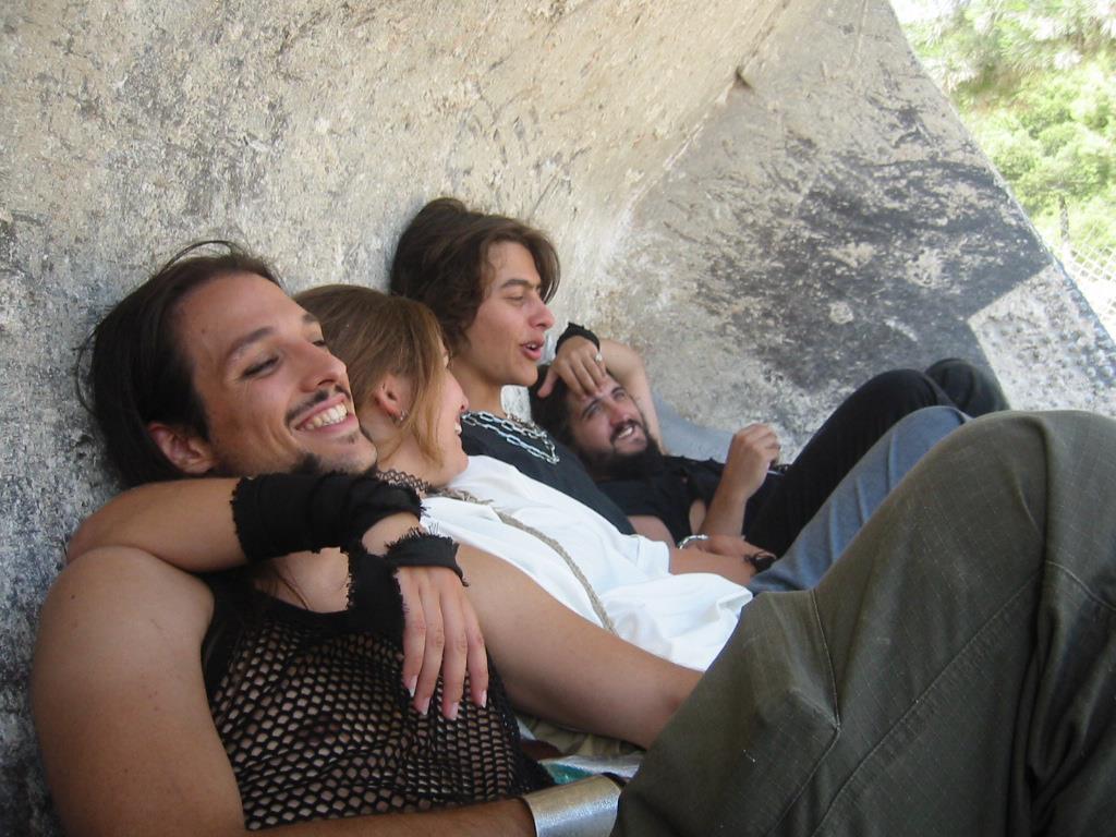 Eduár Campillo dentro de una pala excavadora con una chica que le pasa el brazo sobre el hombre, Hermes y Balsar al fondo. Todos sonríen de forma natural en una foto robada.